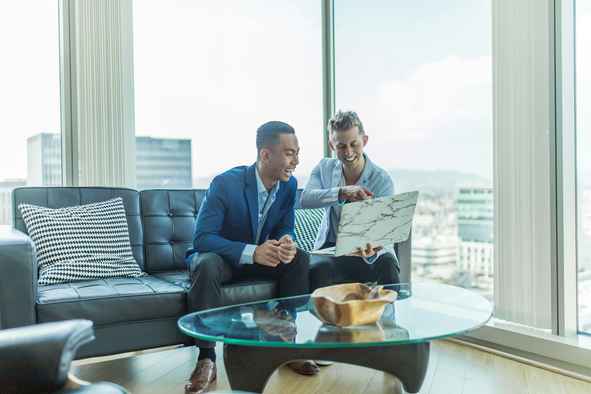 Two REALTORS&reg; reviewing a plan by the window